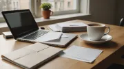 Table de cuisine avec un ordinateur portable ouvert, une tasse de café et des courriers administratifs empilés à côté du clavier